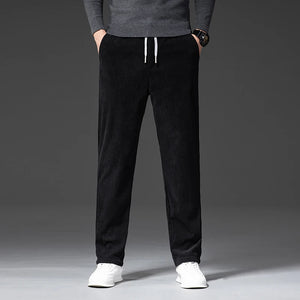 Person wearing black pants with a gray sweater on a gray background