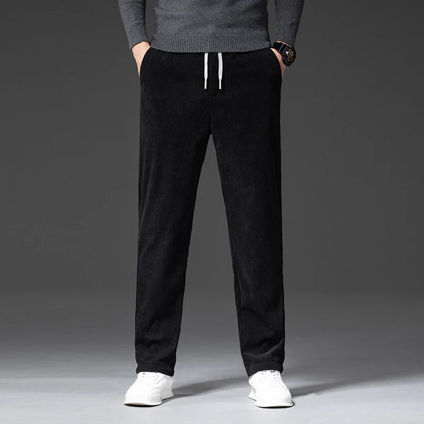 Person wearing black pants with a gray sweater on a gray background