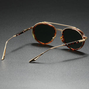 Sunglasses with tortoiseshell frame and dark lenses on a gray background