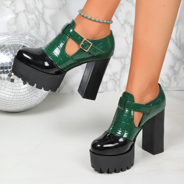 Green platform shoes with black soles worn by a person, with a disco ball in the background.