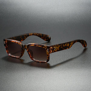 Tortoiseshell sunglasses on a reflective gray surface
