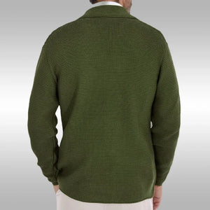 Green sweater worn by a person on a plain background