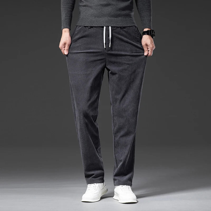 Beige corduroy pants worn by a person on a gray background