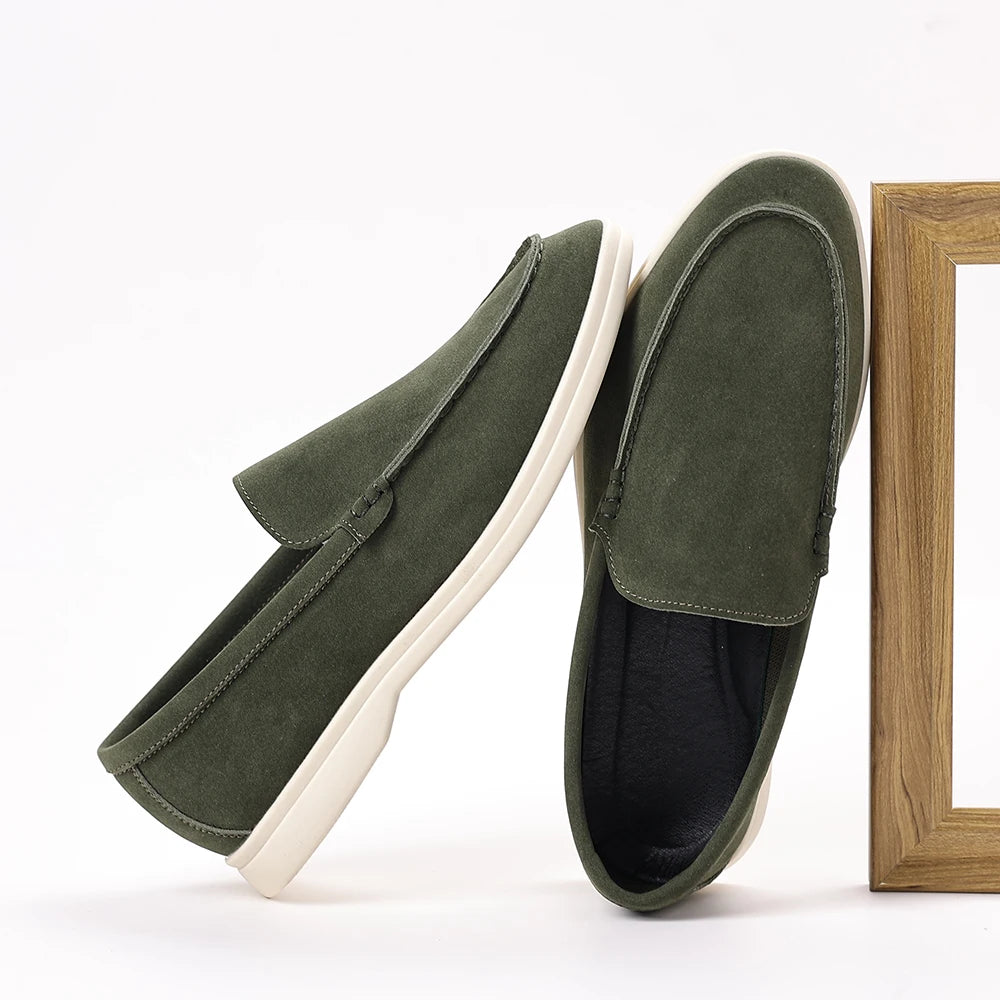Green loafers on a white background with a wooden frame.