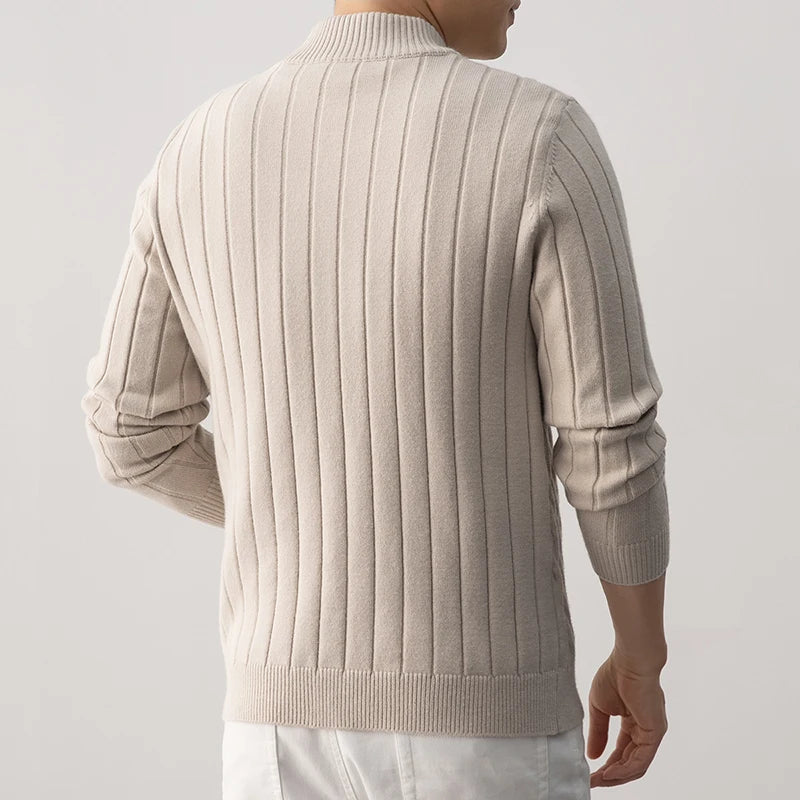 Beige cable knit sweater worn by a person on a light gray background