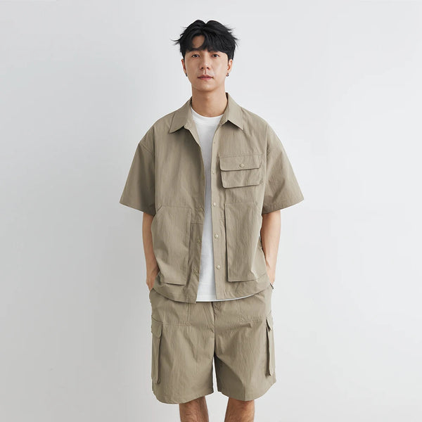 Man wearing a beige short-sleeve shirt and shorts set on a plain background