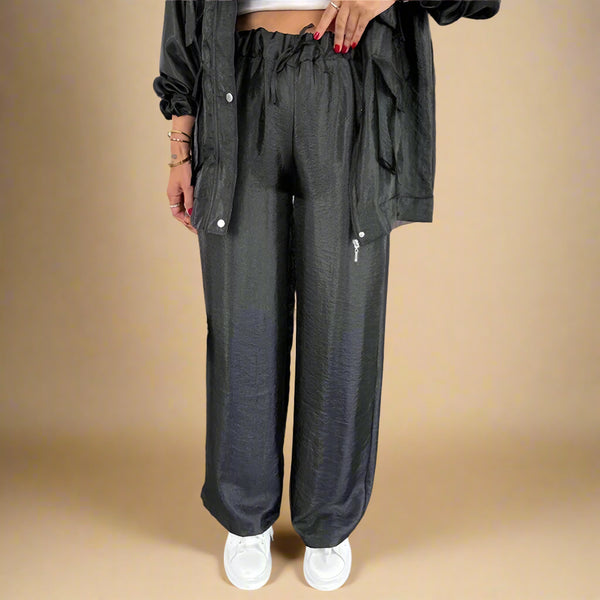 Person wearing dark gray wide-leg pants and a matching jacket indoors.
