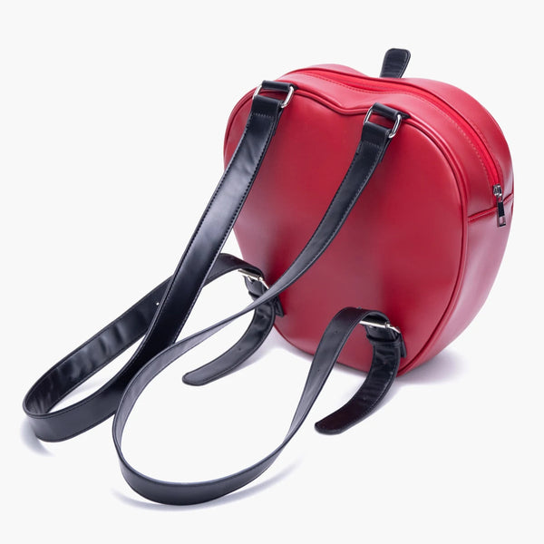 Red heart-shaped bag with black straps on a white background