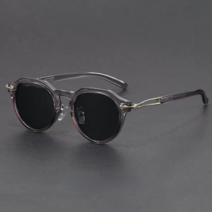 Round sunglasses with dark lenses on a gray background