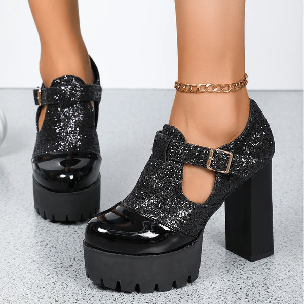 Black glittery platform shoes with high heels on a light gray background