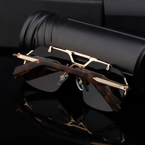 Sunglasses with gold frame and black lenses on a reflective surface