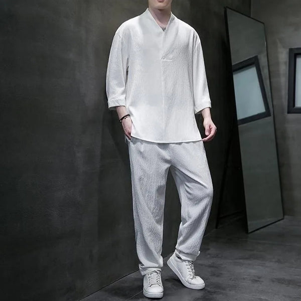 Person wearing a white traditional outfit with a dark background