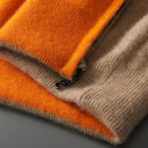 Stack of orange and beige sweaters on a gray surface