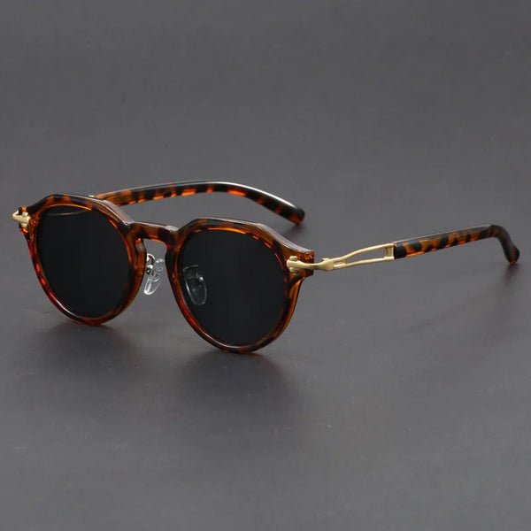 Sunglasses with tortoiseshell frame and dark lenses on a gray background