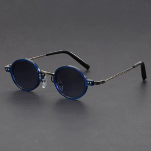 Round blue sunglasses with thin metal frames on a gray background