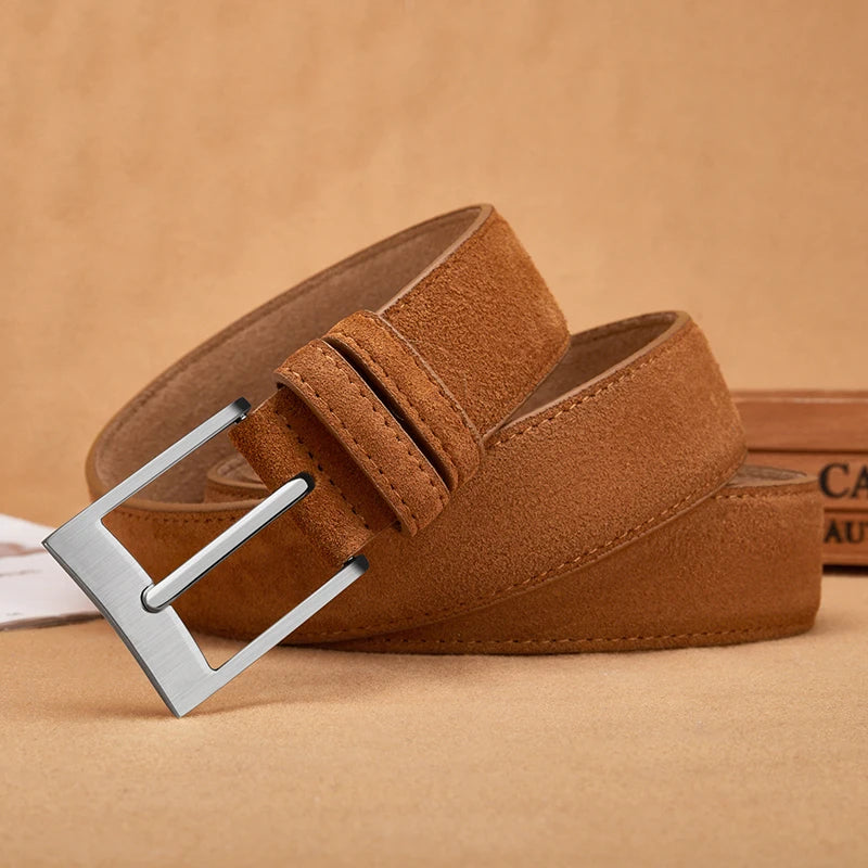 Four belts in gray, brown, and blue with metal buckles on a beige background