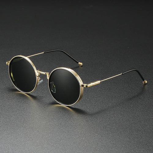 Round sunglasses with gold frame and black lenses on a dark gray background