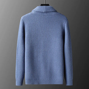 Blue knitted sweater on a gray background