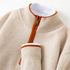Close-up of a beige sweater with orange trim on a white background