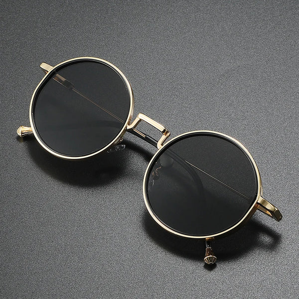 Round sunglasses with gold frame and black lenses on a gray background