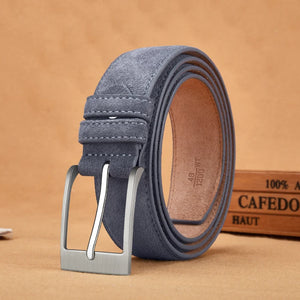 Gray suede belt with silver buckle on a beige background