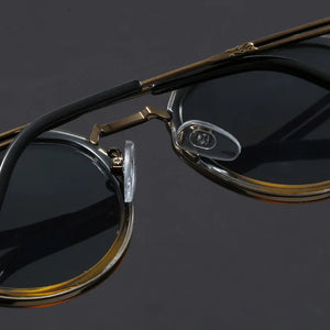 Eyeglasses with gold frame on a reflective black surface