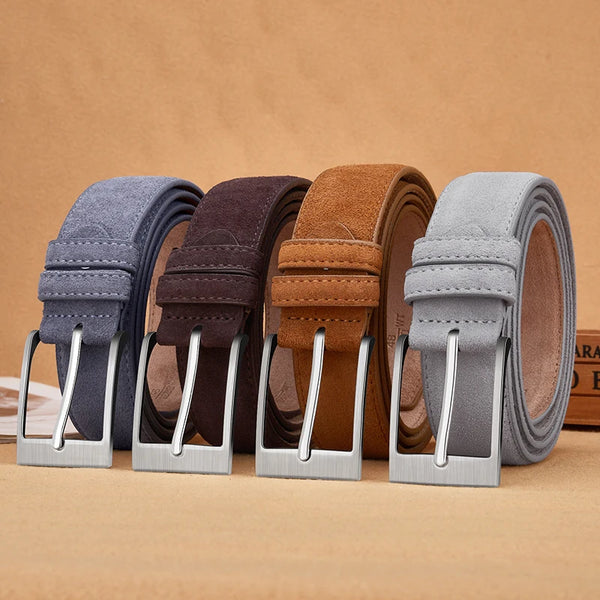 Four belts in gray, brown, and blue with metal buckles on a beige background