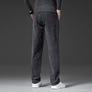 Person wearing dark gray jogger pants on a gray background
