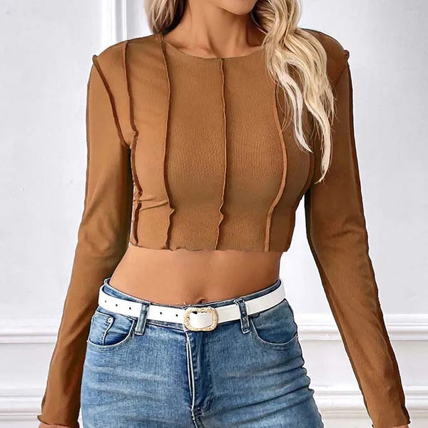 Person wearing a brown long-sleeve top and blue jeans with a white belt.