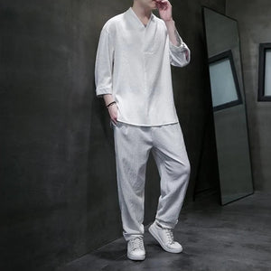 Person wearing a white traditional outfit in a dark room setting