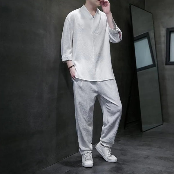 Person wearing a white traditional outfit in a dark room setting
