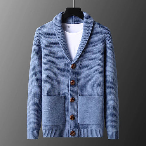 Blue knitted cardigan with brown buttons on a gray background