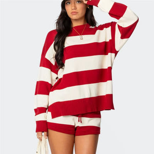 Woman wearing a red and white striped sweater and shorts on a plain background