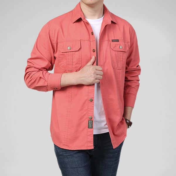 Person wearing a coral pink shirt with a white background