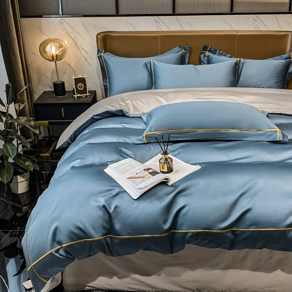 Blue bedding set on a bed with a side table and lamp in a bedroom setting