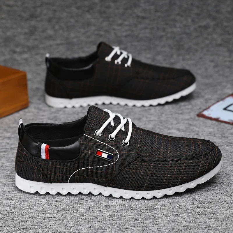 Gray casual shoes with white soles on a wooden surface