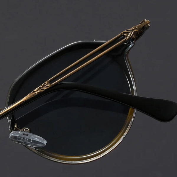 Vintage-style eyeglasses with decorative arm on a dark background