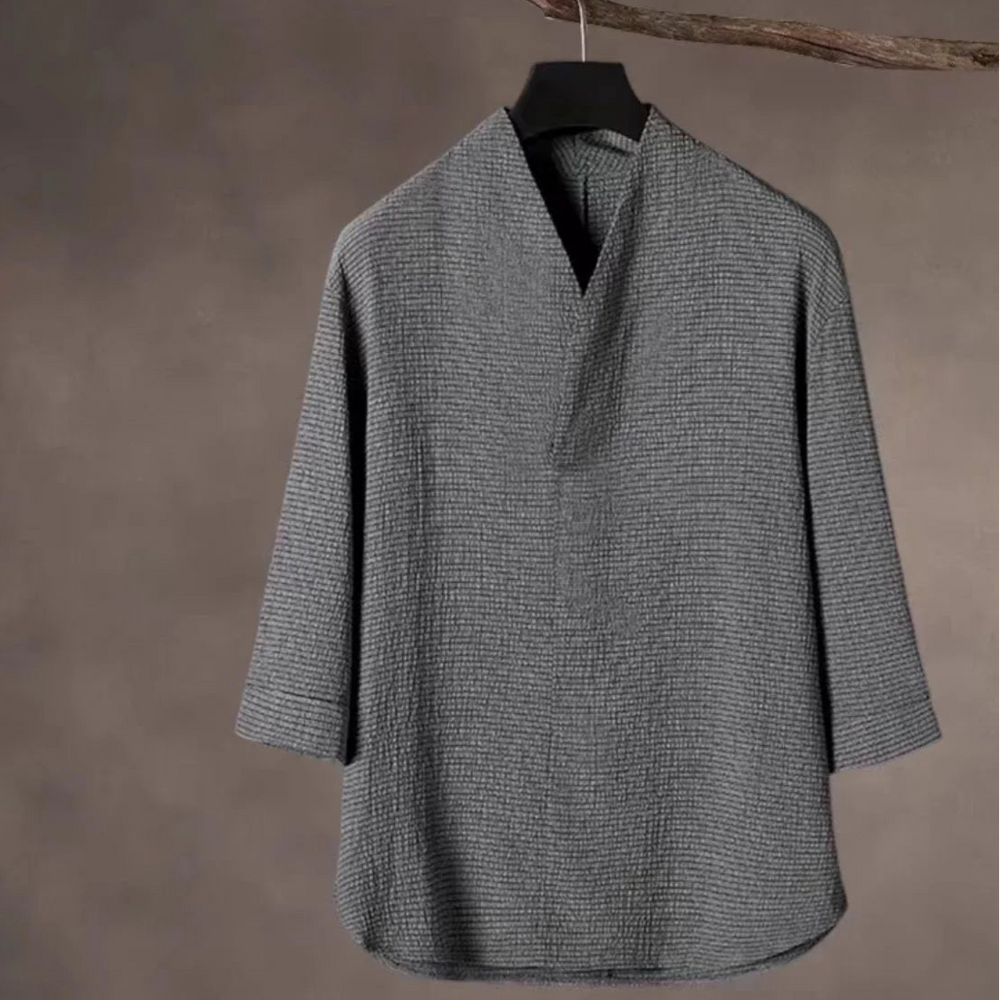 White shirt and pants set on hangers against a gray background