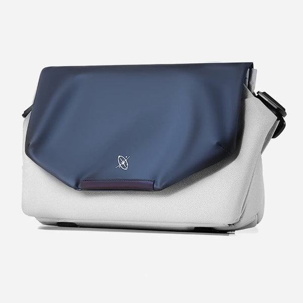 Blue and white shoulder bag with a visible brand logo on a light gray background