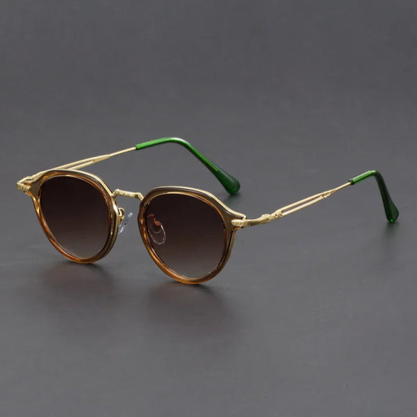 Round sunglasses with gold frames and dark lenses on a gray background