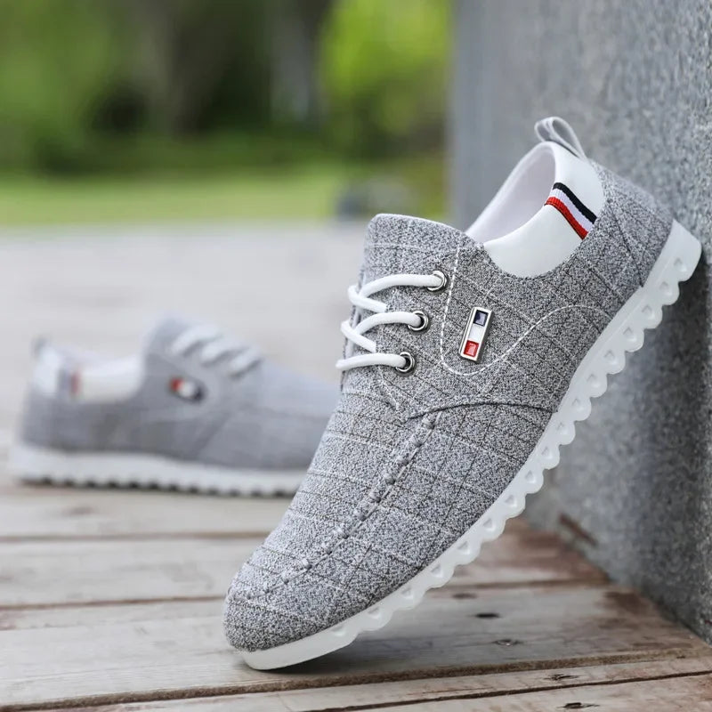 Gray casual shoes with white soles on a wooden surface