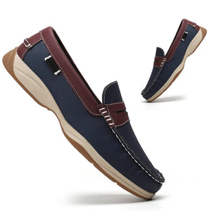 Pair of navy loafers with brown accents on a white background