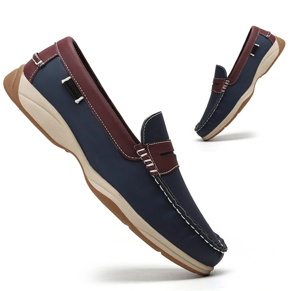 Pair of navy loafers with brown accents on a white background