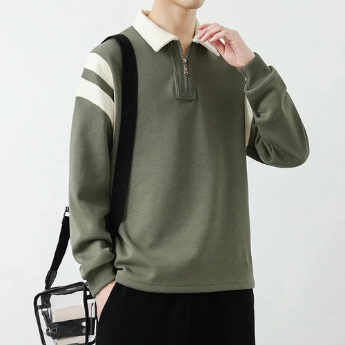 Person wearing a green long-sleeve shirt with white collar and stripes on sleeves against a light gray background