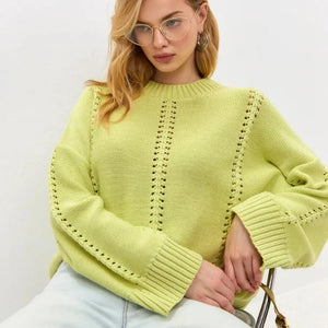 Woman wearing a light green sweater with a white background