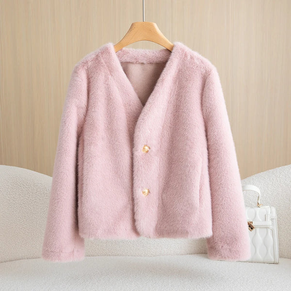 Pink fluffy jacket on a hanger against a beige wall.