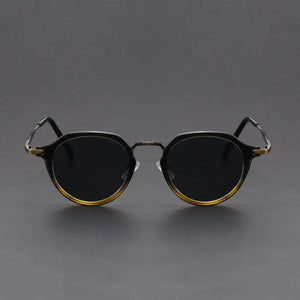 Round sunglasses with gold frames on a gray background