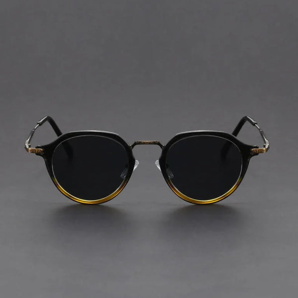 Round sunglasses with gold frames on a gray background
