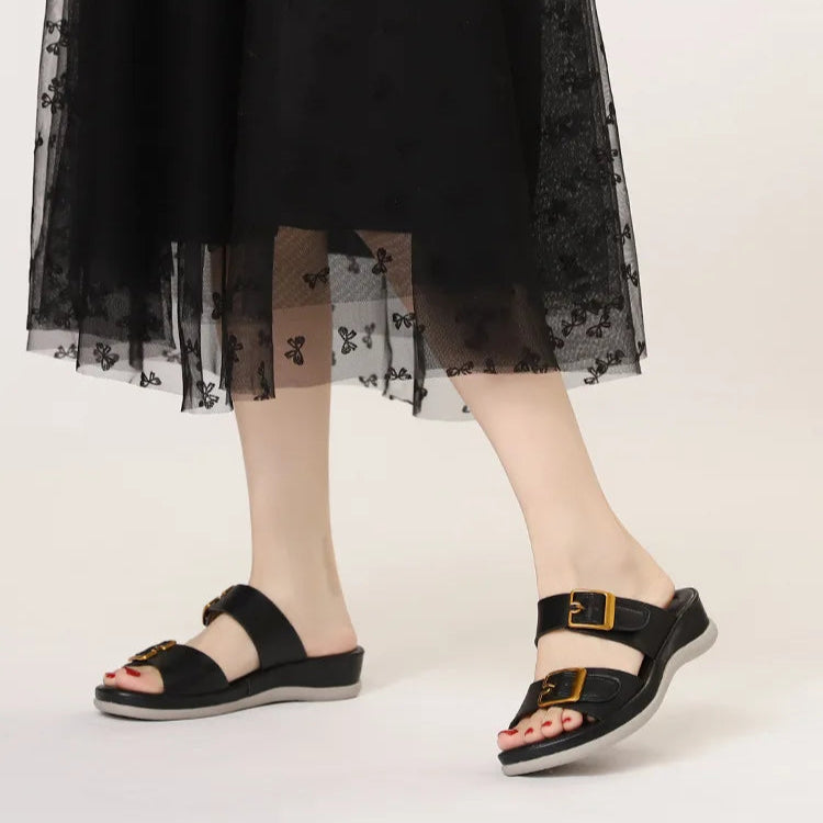 Four pairs of sandals in black, brown, and beige with gold buckles on a white background.