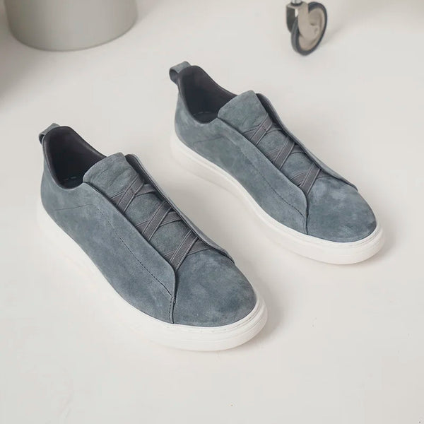 Pair of gray slip-on sneakers on a white background